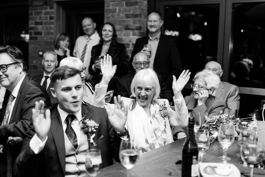 Wedding guests standing and sitting during the stand up, sit down game