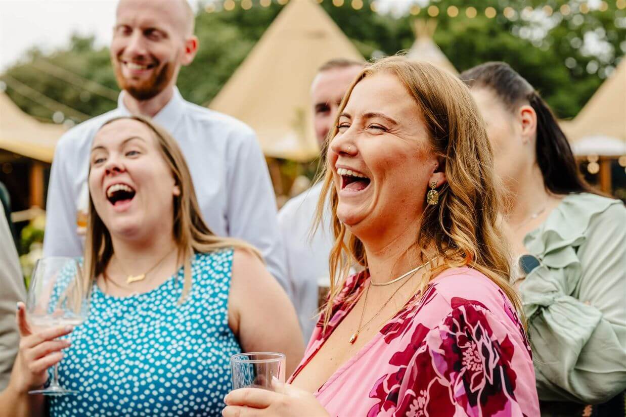 Wedding guests laughing during a comedy magic performance