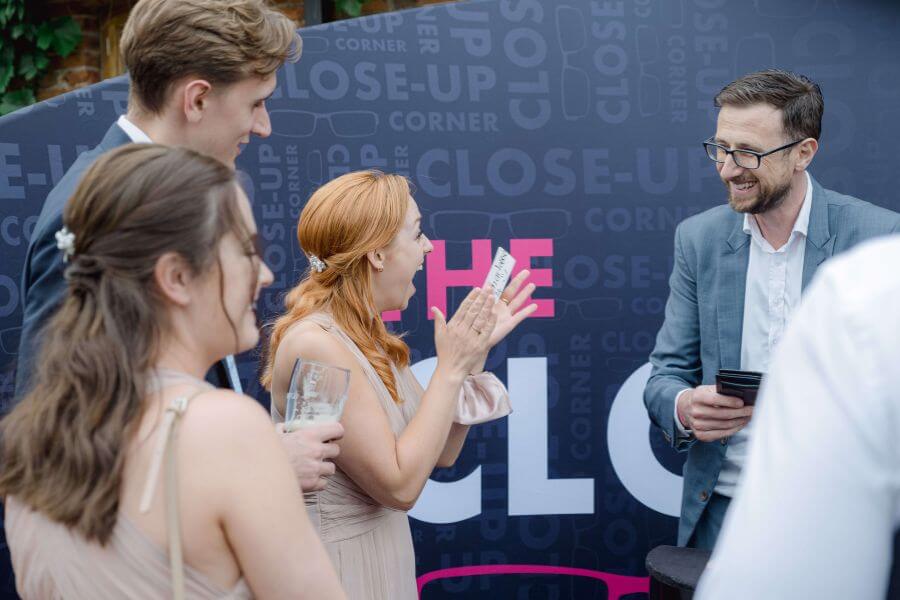 Guests reacting to close-up magic at the Close-Up Corner