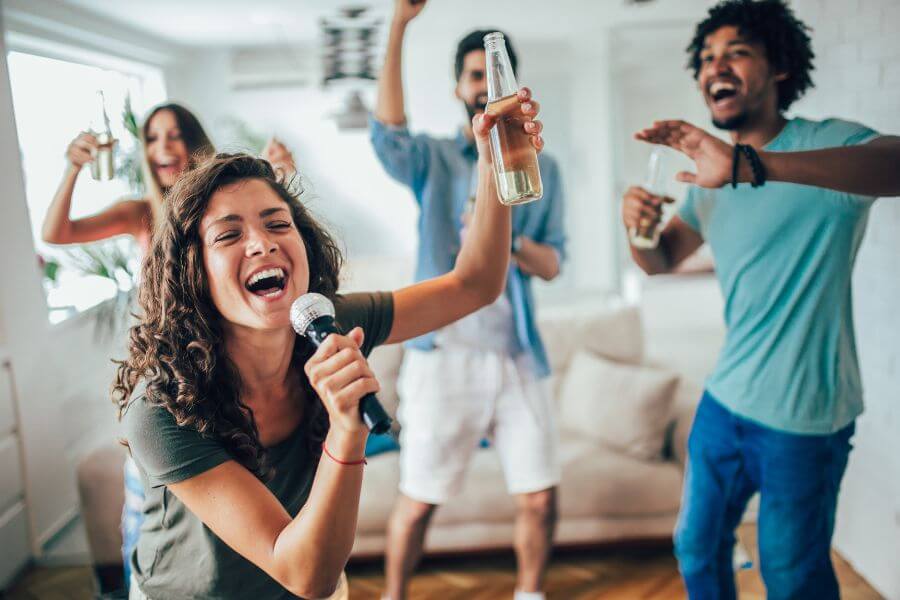 Dinner party guests singing karaoke
