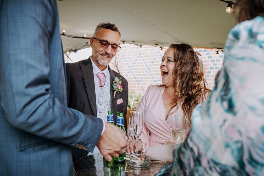 Wedding guests laughing at close-up magic at Alrewas Hayes