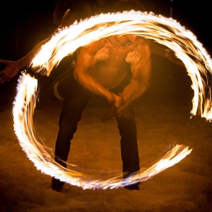 Wedding fire performers dancing at an evening outdoor reception