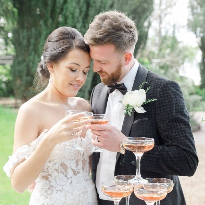 Champagne tower being poured at a wedding reception