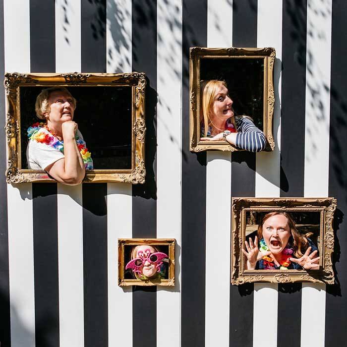Wedding guests posing in an ornate framed selfie photo op