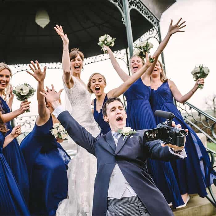 Wedding guests filming candid video messages with disposable cameras