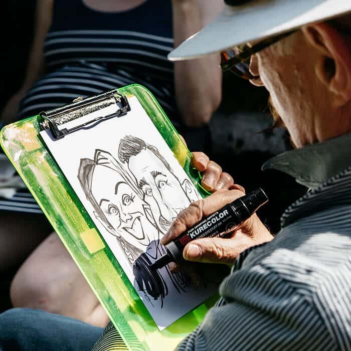 Finished caricature being shown to a delighted guest