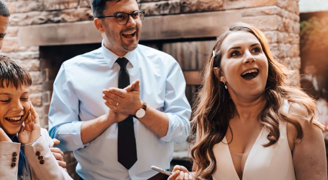 Wedding magician performing close-up magic — bride reacting