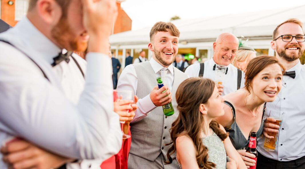 Wedding guests reacting to close-up magic at drinks reception