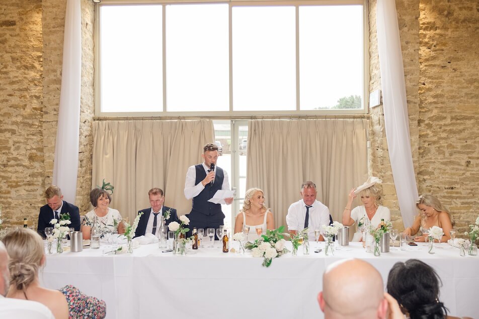 A groom giving a speech at the wedding reception