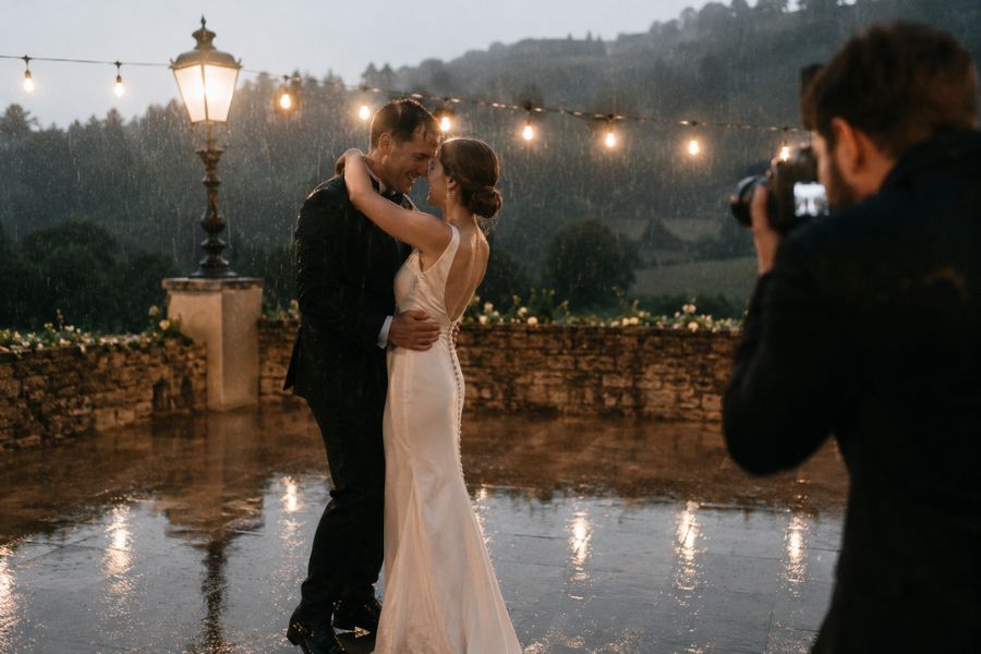 Newlyweds dancing in the rain on their wedding day