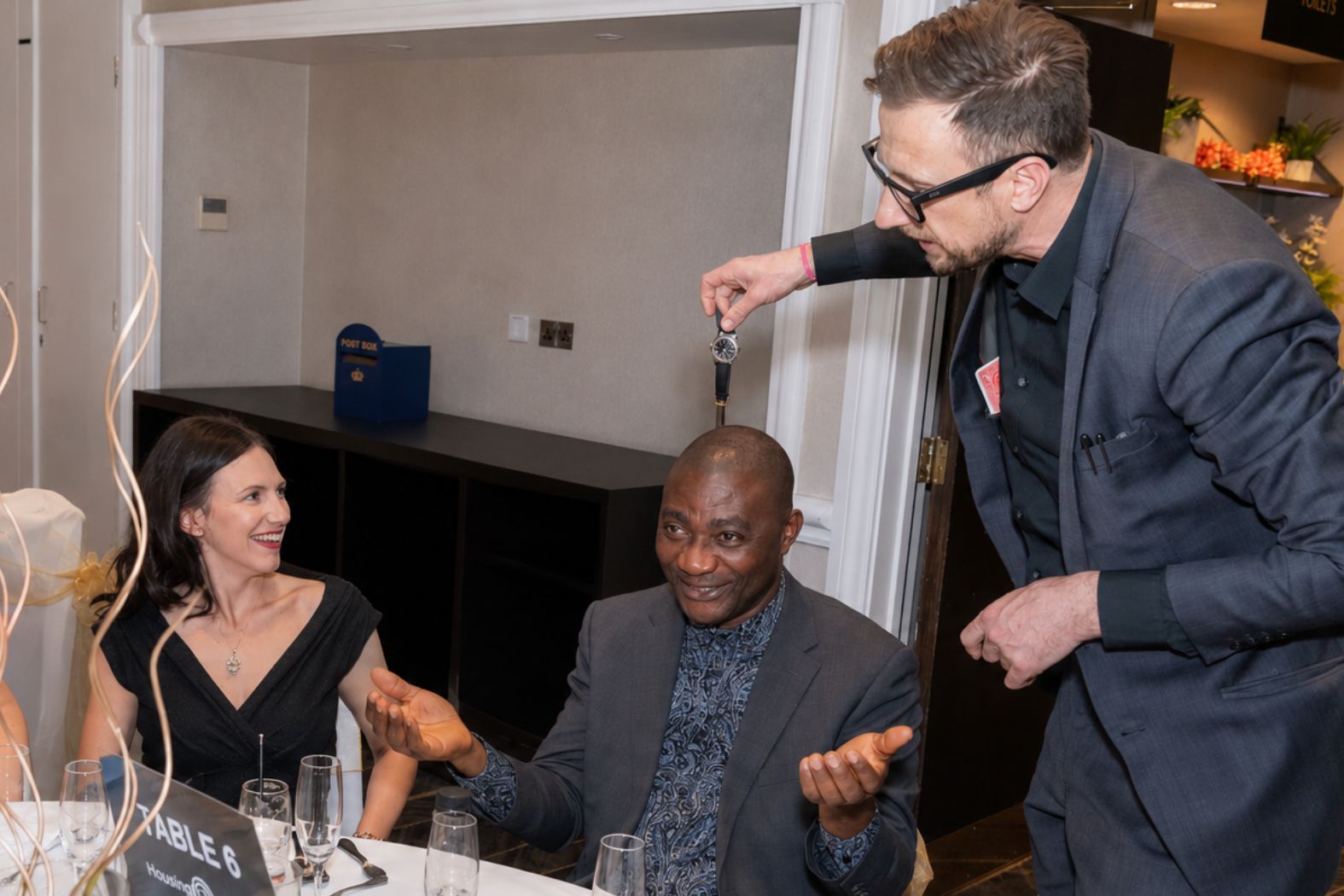 Close-up magician lifting a watch from a guest's wrist