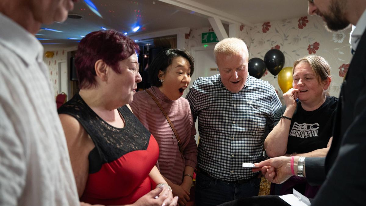 A group reacting together to a magic reveal