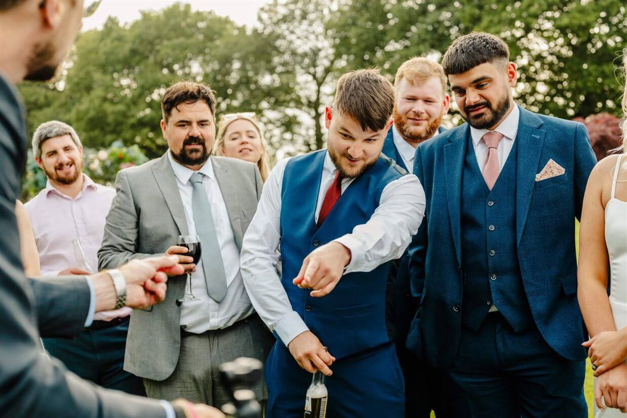 Crowd of wedding guests watching close-up magic at Tipis at Riley Green