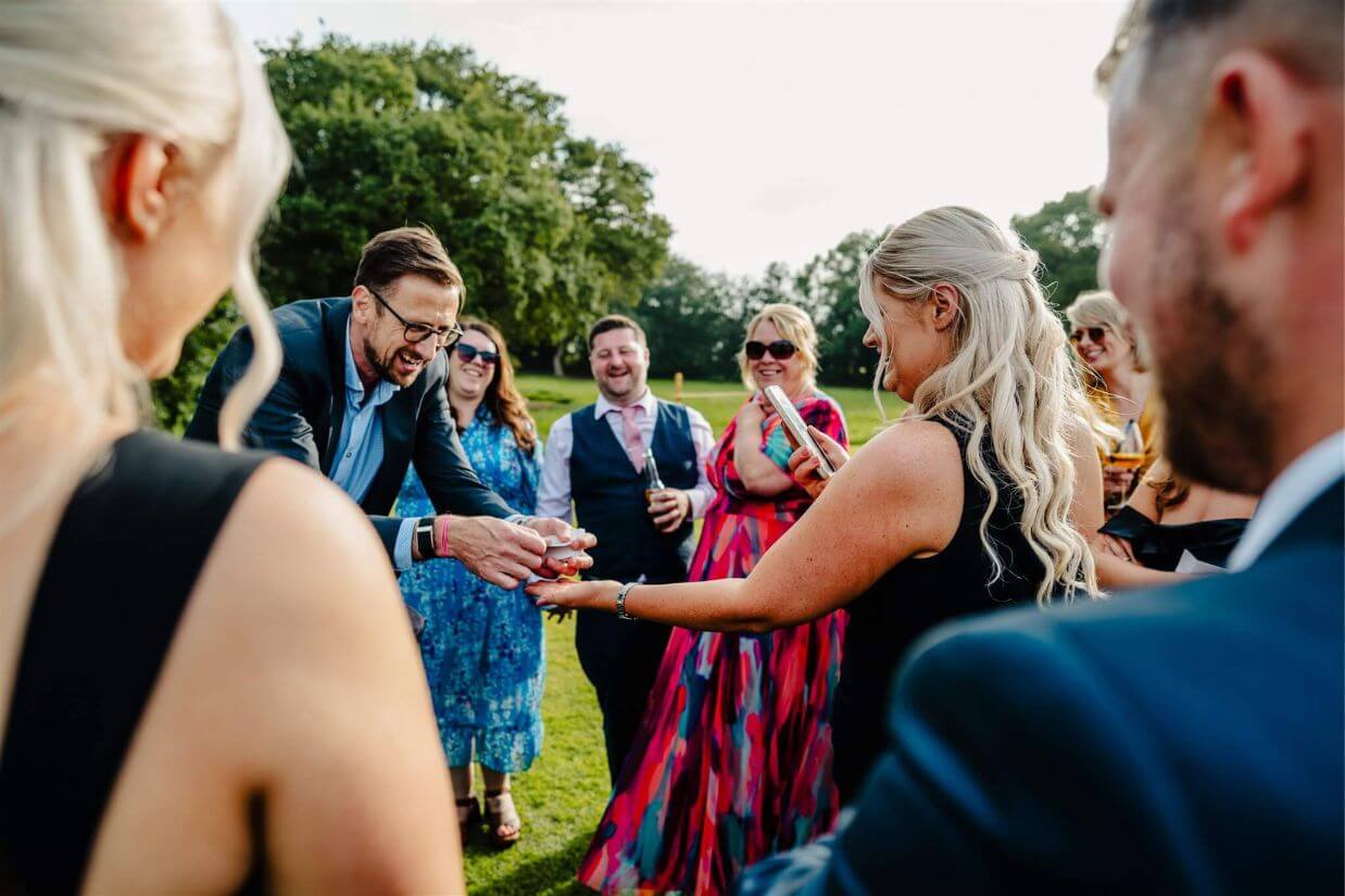 Bride watching a close-up magic trick at her tipi wedding
